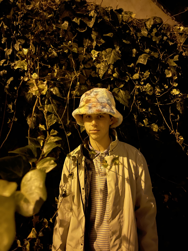 picture of brendon posing  in front of a wall of ivy